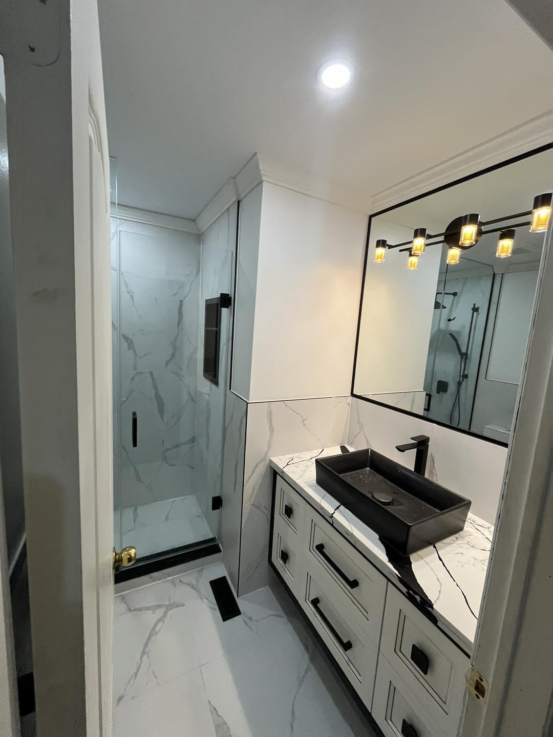 Modern Bathroom with Black Fixtures and Marble Tile — image 1